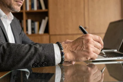 Bracelet en pierres naturelles labradorite porté par un homme en costume gris au bureau